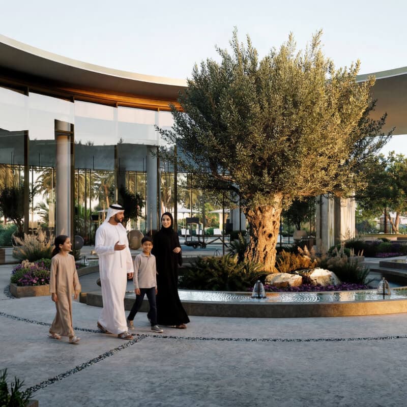 Fay Valley Phase 2 community clubhouse exterior with pools and landscaping, Masdar City